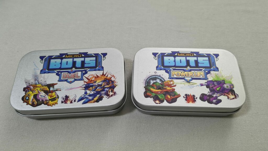 a photograph of micro bots duel and the power up expansion tins