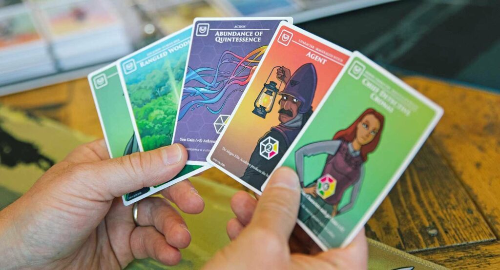 a hand holding a series of achroma cards